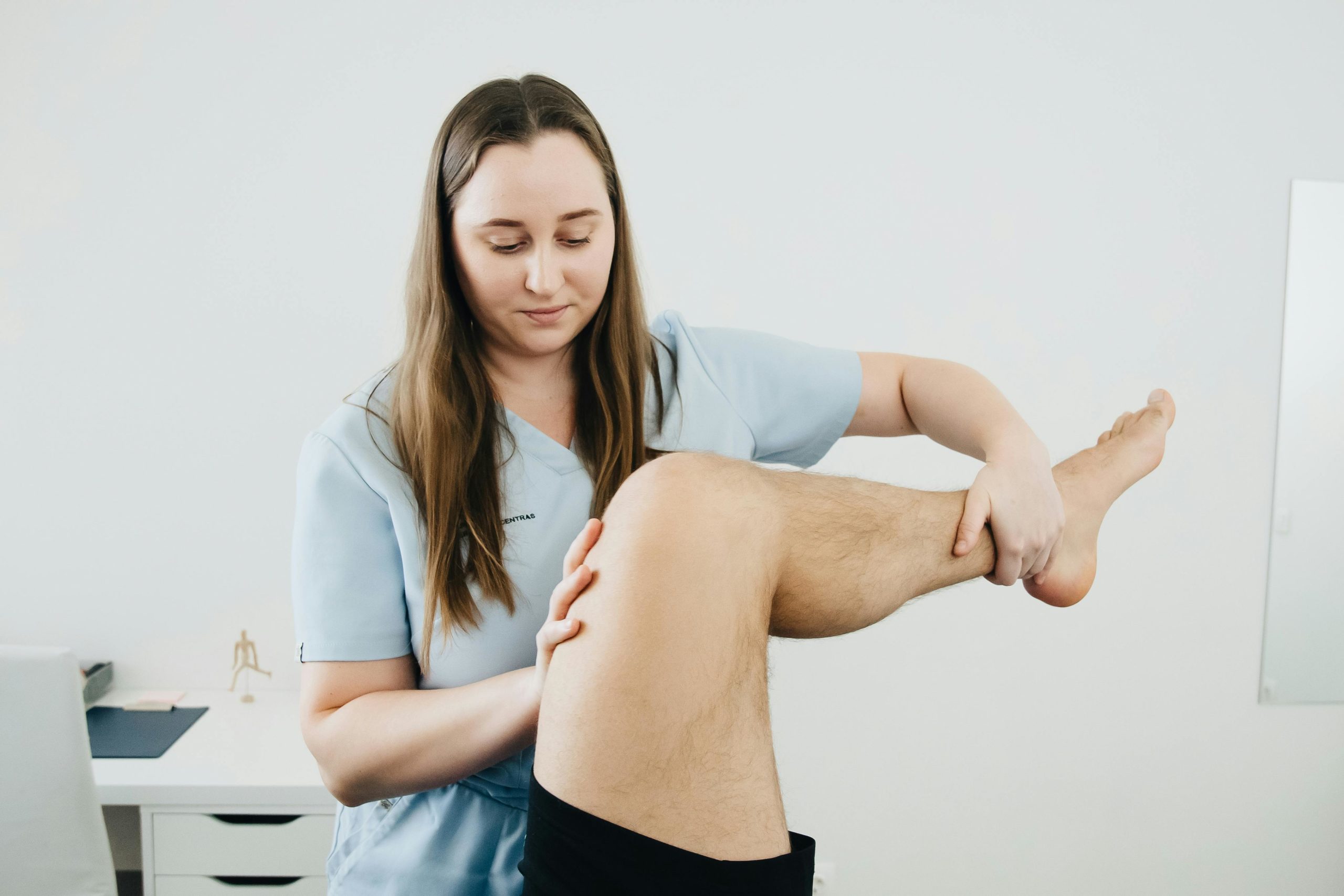 A massage therapist holding a clients leg by the ankle